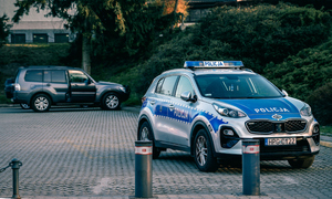 radiowóz policjantów, w tle podstawione auto z ładunkiem wybuchowym