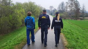od prawej dzielnicowa, strażnik miejski i ratownik wodny idą ścieżką po wale przeciwpowodziowym