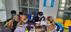 KPP Oświęcim. Razem tworzymy atmosferę. Kibicuj z klasą policjantki z uczniami przy stoisku profilaktycznym
