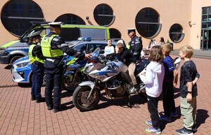 KPP Oświęcim. Razem tworzymy atmosferę. Kibicuj z klasą policjanci i uczniowie na stoisku z radiowozami i motocyklami