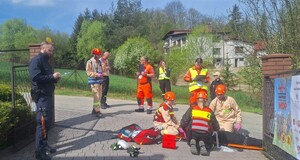Scenka z poszkodowaną osobą. Nadzoruje policjant, przdstawiciel medyczny i strażak