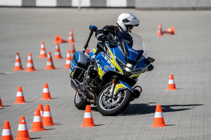 Policjant jadący na motocyklu między pachołakmi