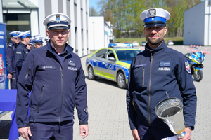 Naczelnik wraz z policjantem trzymającym puchar