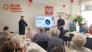 policjanci prezentujący Małopolski Tele-anioł na spotkaniu z seniorami