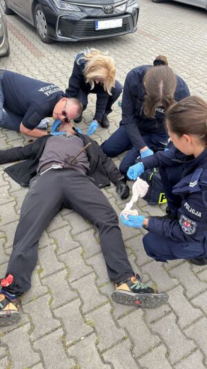 mezczyzna lezacy na ziemi z wbitym pretemw  brzuch obok dwie policjantki, straznik imiejski ze Słowacji