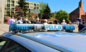 Belka sygnalizacyjna radiowozu, w tle uczestnicy uroczystości