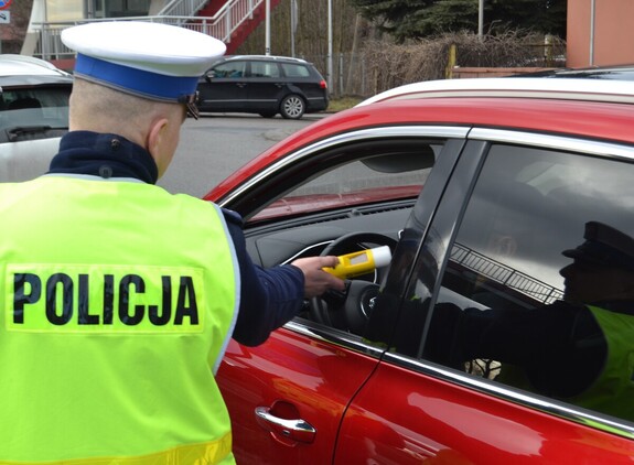 Policjant ruchu drogowego badający trzeźwość kierujacego
