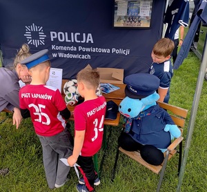 Trzech chłopców przy stoisku policyjnym