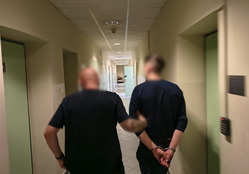 Policjant prowadzi zatrzymanego