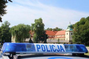 zdjęcie kogutów policyjnych na tle zamku suskiego w trakcie słonecznej pogody