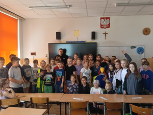 zdjęcie grupowe uczniów z policjantką w sali lekcyjnej