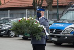 szef małopolskich policjantów z asystą kapelana policyjnego składają wieniec w imieniu policjantów pod obeliskiem