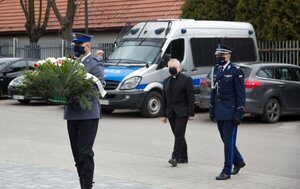szef małopolskich policjantów z asystą kapelana policyjnego składają wieniec w imieniu policjantów pod obeliskiem