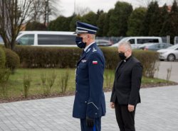 szef małopolskich policjantów z asystą kapelana policyjnego składają wieniec w imieniu policjantów pod obeliskiem