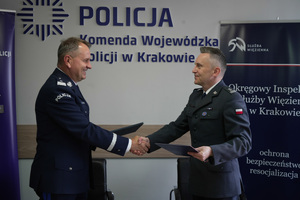 Podpisanie dwustronnego porozumienia przez nadinspektora Artura Bednarka Komendanta Wojewódzkiego Policji w Krakowie oraz podpułkownika Szymona Glicy Dyrektora Okręgowego Służby Więziennej w Krakowie - moment przekazania porozumień