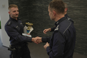 Komendant wręcza nagrodę policjantowi