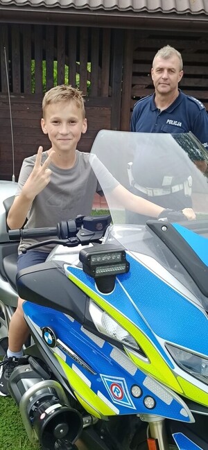 Chłopiec siedzący na motocyklu policyjnym