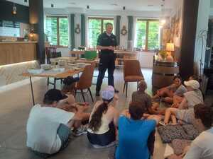 dzielnicowy stojący przed grupą młodzieży uczestniczącej w prelekcji