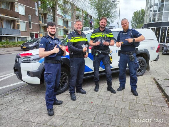 Policjanci polscy oraz holenderscy na tle radiowozu wraz z naszywkami