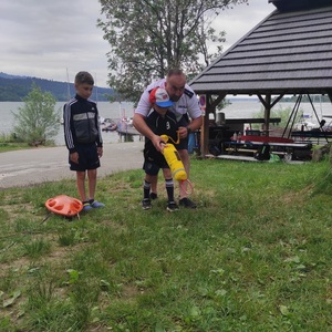policjant uczy dzieci pierwszej pomocy nad wodą