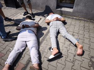 dwóch zatrzymanych mężczyzn leży na ziemi