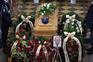 trumna z ciałem Zmarłego, obok jego zdjęcie, wieńce i asysta honorowa