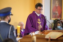 Ksiądz przemawia z ambony podczas mszy żałobnej kapelana