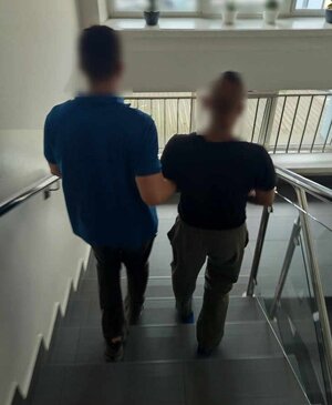 zatrzymany prowadzony po schodach