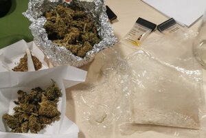 susz marihuany rozłożony na sreberku i dwóch kartkach papieru