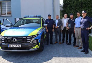 Przekazanie radiowozów Hyundai i Toyoty wspólne zdjęcie policjantów i przedstawicieli samorządów przy radiowozie dla wydziału prewencji