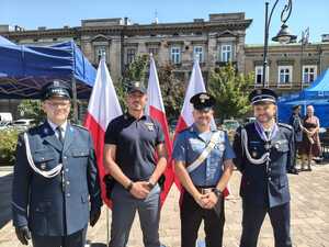 dwóch włoskich policjantów na wspólnym zdjęciu z dwoma krakowskimi funkcjonariuszami podczas obchodów Święta Policji na Rynku Podgórskim