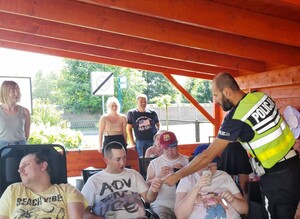 Spotkanie z podopiecznymi Promyka policjant wręcza odblaski