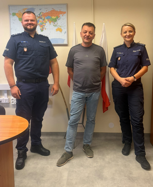 policjantka i policjant w mundurach pomiędzy nimi stoi mężczyzna po cywilnemu