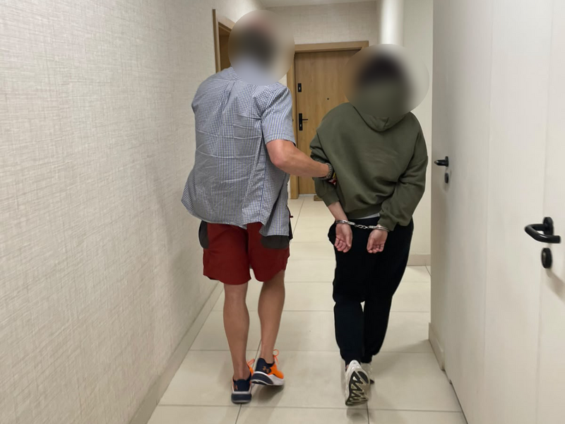 nieumundurowany policjant prowadzi osobę zatrzymaną
