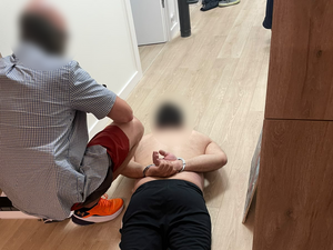 zatrzymany, zakuty w kajdanki leży na podłodze