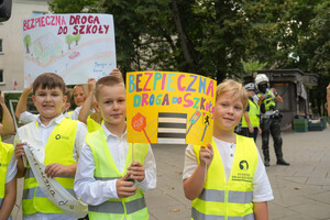 Dzieci trzymające w ręku transparenty z hasłami bezpieczeństwa na drodze