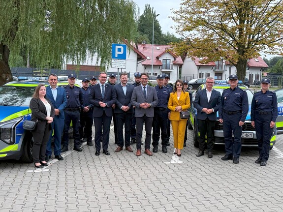 Wspólne zdjęcie samorządowców oraz policjantów KPP Wieliczka przy radiowozach