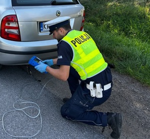 Kontrola emisji spalin w pojeździe kontrolowana przez policjanta ruchu drogowego