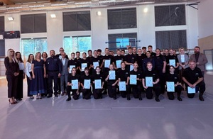 Zdjecie grupowe, na którym są uczniowie klas policyjnych, policjant i policjantki oraz kobiety i mężczyźni w stroju cywilnym.