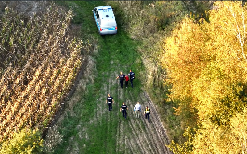 widok z drona  policjanci prowadzą zatrzymanego