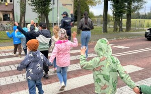 Policjantka z uczniami na przejściu dla pieszych