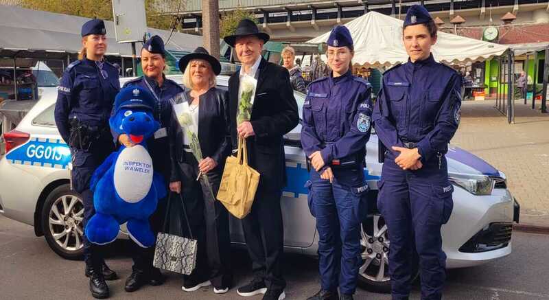 policjantki wraz z parą Seniorów na pamiątkowym zdjęciu przed radiowozem