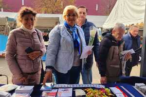 seniorzy przy stanowisku policyjnym z materiałami edukacyjnymi
