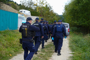 kolumna piesza policjantów na drodze leśnej