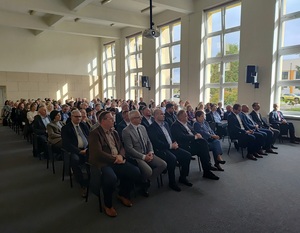Grupa osób, kobiet i mężczyzn, którzy siedzą na krzesłach