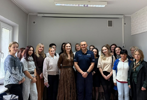 Zdjęcie grupowe. Umundurowany policjant oraz osoby biorące udział w szkoleniu