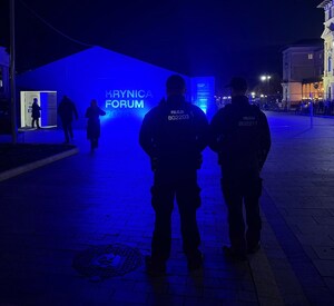 noc, dwóch umundurowanych policjantów w pobliżu pawilonu z napisem Forum Krynica 2026