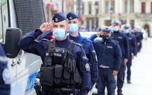 Policjanci oddają cześć. Zbliżenie na policjanta oddziału prewencji