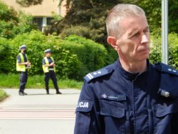 naczelnik ruchu drogowego KWP w Krakowie, a w tle para policjantów w rejonie przejścia dla pieszych