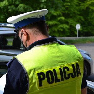 policjant ruchu drogowego w białej czapce i kamizelce odblaskowej